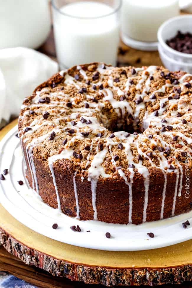 The best Banana ANYTHING ever! Moist Banana Coffee Cake riddled with chocolate chips and walnuts (optional) with an INCREDIBLY creamy cheesecake-like cream cheese filling all topped with brown sugar walnut streusel and vanilla drizzle. 