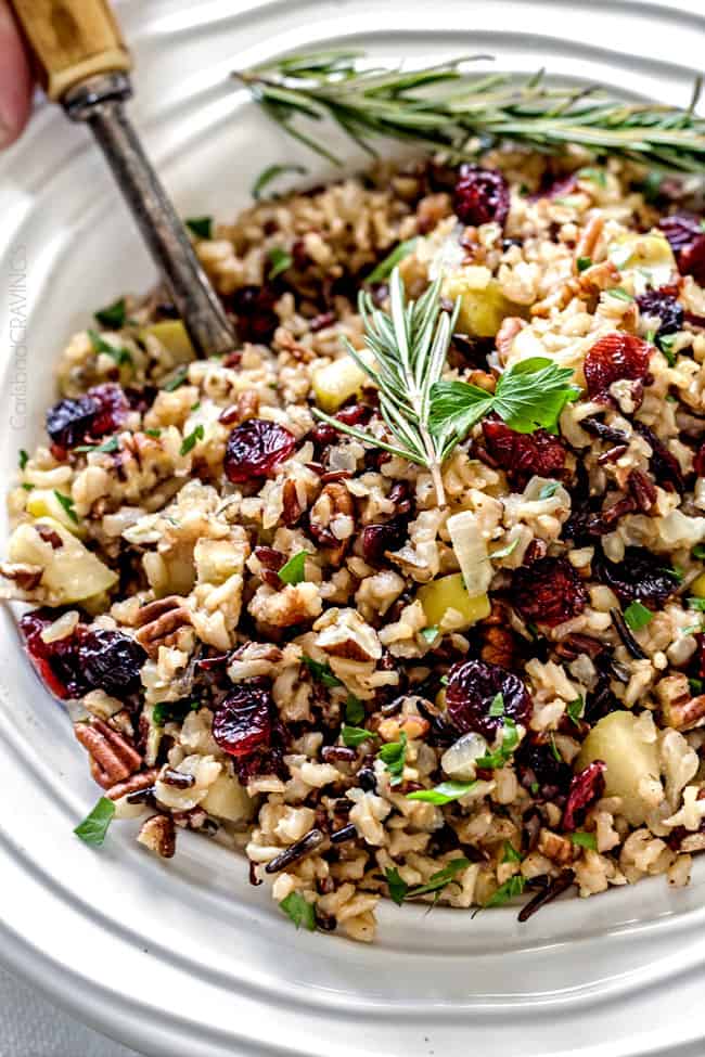Easy one pot Cranberry Apple Pecan Wild Rice Pilaf simmered in herb seasoned chicken broth and apple juice and riddled with sweet dried cranberries, apples and roasted pecans for an unbelievable savory sweet side dish perfect for the holidays. Everyone always asks for this recipe! 